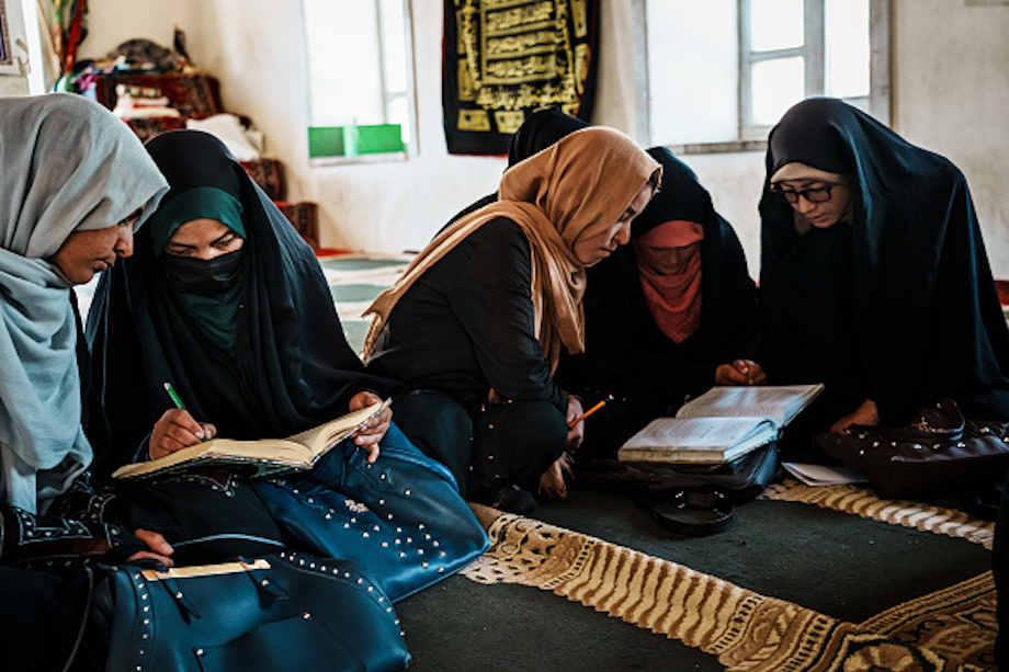 Afghan women reading books in a classroom